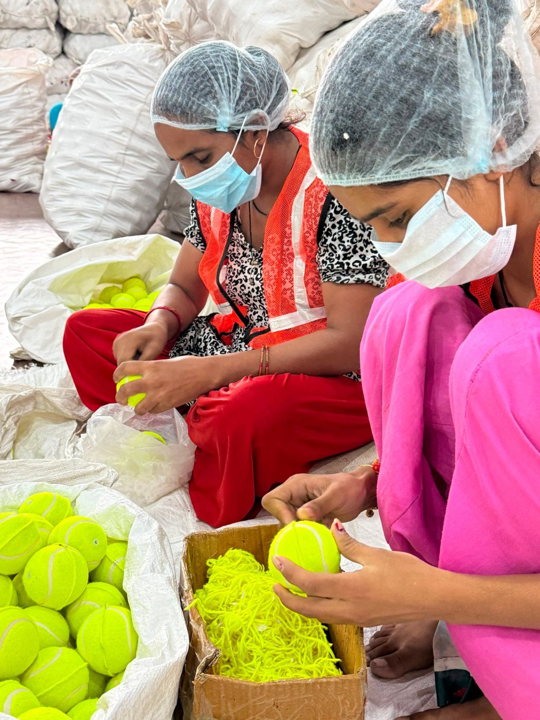 Workers trimming felt ridges on finished balls